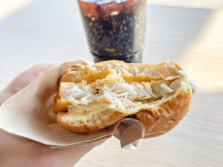 Having a fresh fish burger with soda