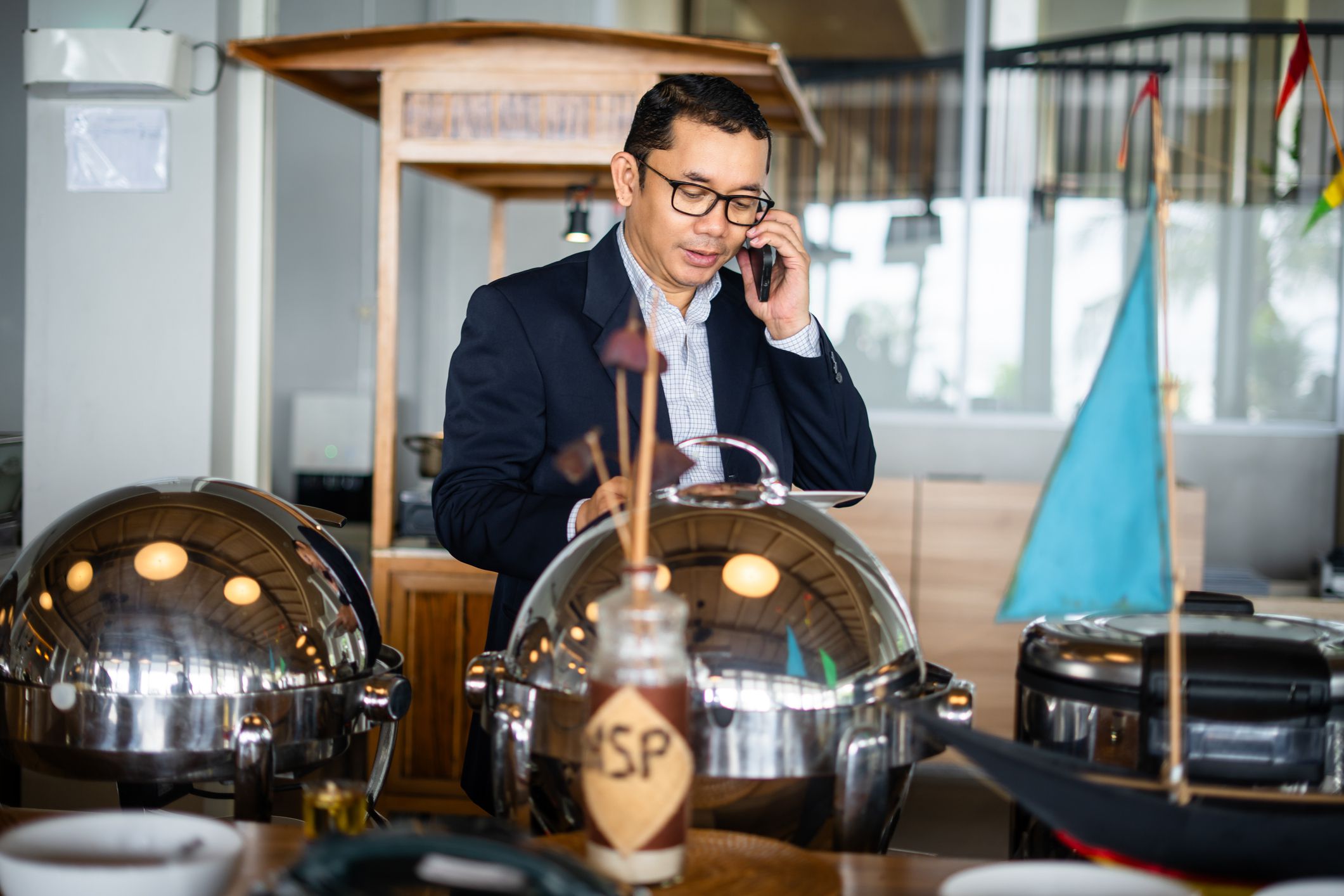Businessman in self service breakfast room in hotel, preparing a plate.
