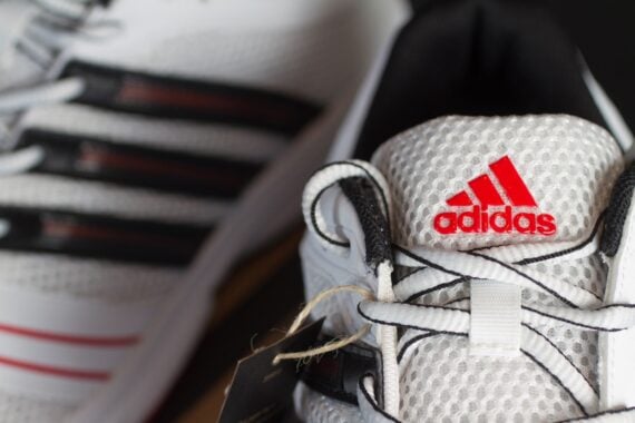 Red Adidas logo on a white nylon running shoe