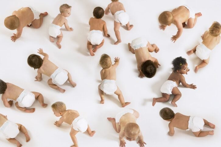Group of multiethnic babies crawling isolated on white background