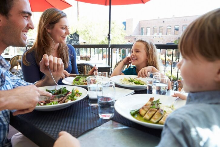 family enjoying meal at outdoor restaurant