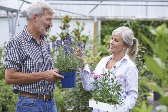 Mature Couple Choosing Plants At Garden Center