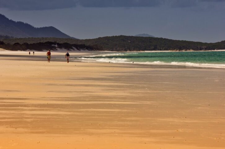 Whitsunday Island, Australia – October 16, 2013: Couples walking along Whitehaven Beach on Whitsunday Island, Australia on October 16, 2013. It has 7km of 98% pure silica sand, which stays cool under foot even on hot days.