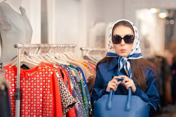 Surprised retro young woman in a raincoat in a clothing store