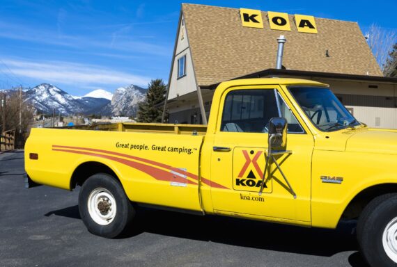 Estes, Colorado, USA - March 9, 2014: A KOA campground truck in Estes with Rocky Mountains in the background. Kampgrounds of America is a chain of camping sites with locations across America.