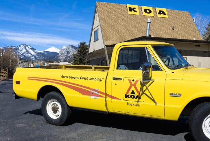 Estes, Colorado, USA - March 9, 2014: A KOA campground truck in Estes with Rocky Mountains in the background. Kampgrounds of America is a chain of camping sites with locations across America.