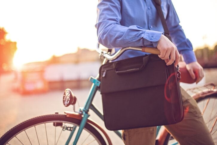 hipster businessman on bike with laptop bag