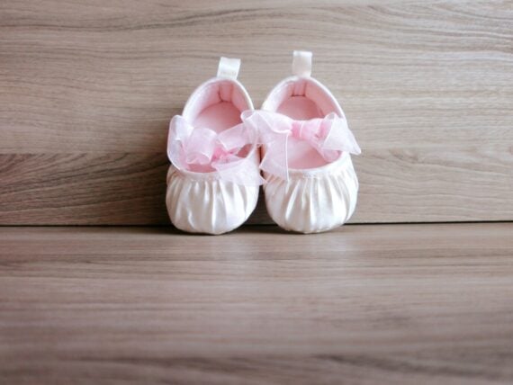 Baby girl shoes on wooden background