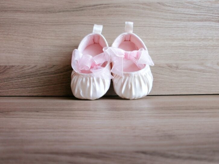 Baby girl shoes on wooden background
