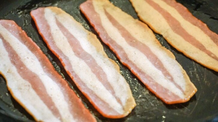 Turkey Bacon being cooked in a Pan.