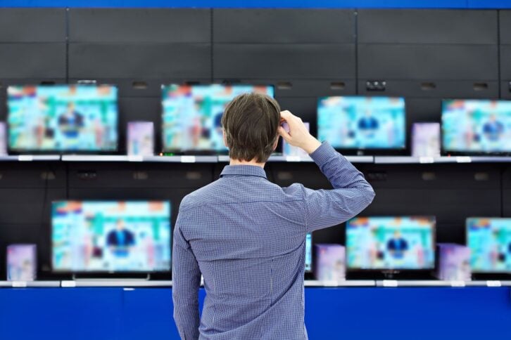 man looking at tvs in store