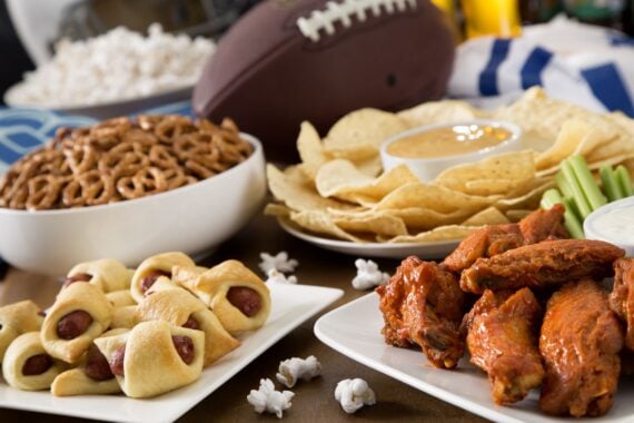 Hot wings, nachos, pigs in a blanket, beer, and popcorn, a tailgate party spread.  Please see my portfolio for other food and drink images.