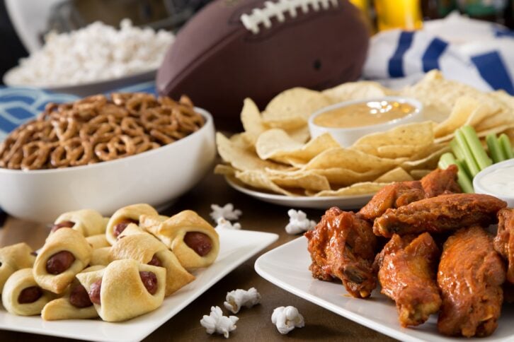 Hot wings, nachos, pigs in a blanket, beer, and popcorn, a tailgate party spread.  Please see my portfolio for other food and drink images.