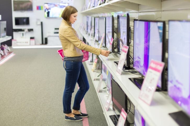 woman chooses a TV in the store