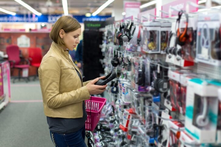 woman chooses headphones store