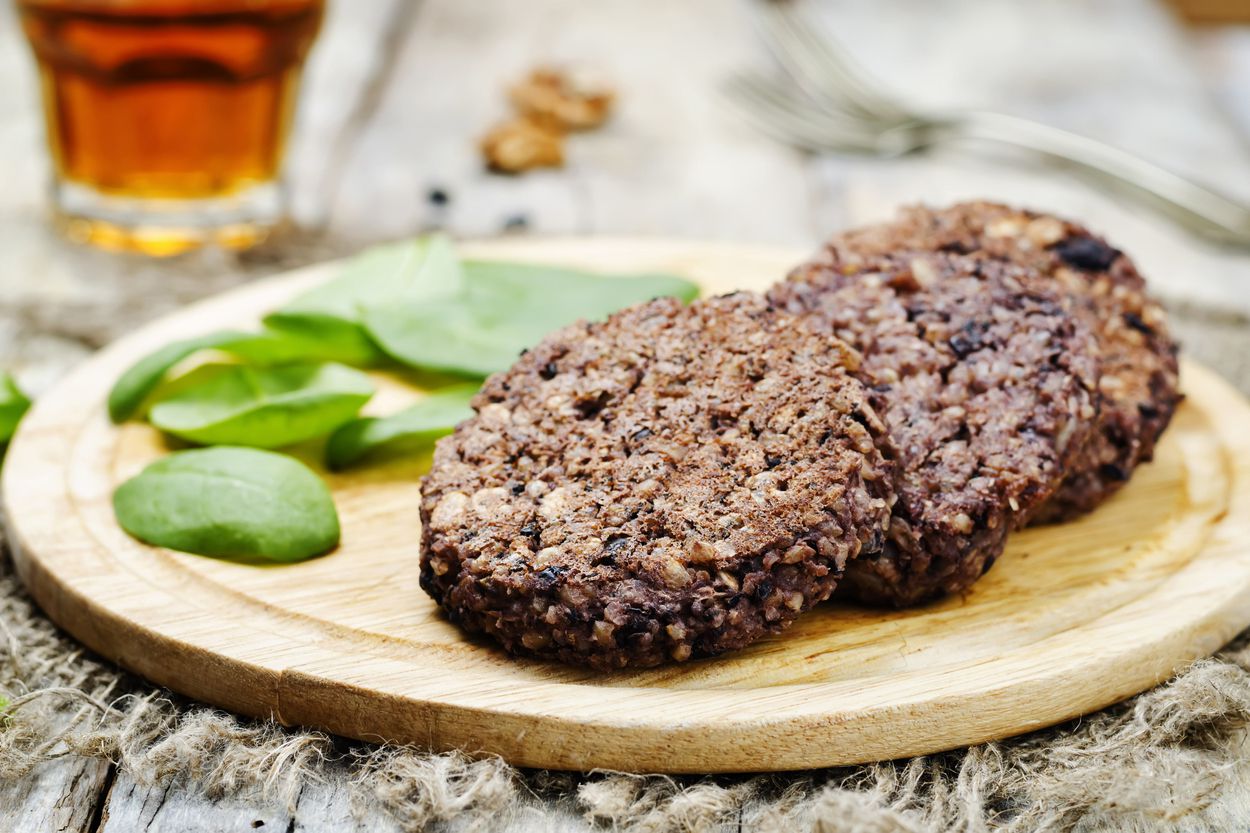 black bean cakes on wooden plate garnished with spinach
