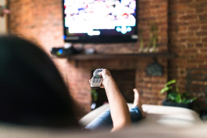 woman relaxing online on sofa reading some papers