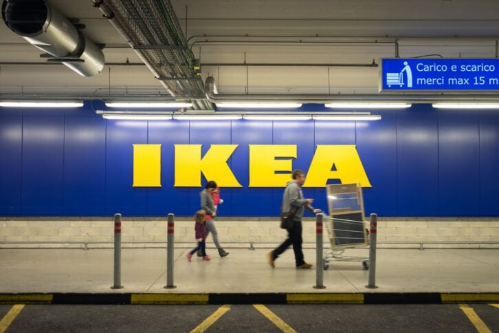 Chieti, Italy - November 19, 2016: A family walking in the car parking after shopping at Ikea store; the big sign of the store is in the background. Ikea is one of the largest (if not the largest)  ready-to-assemble furniture retailer.