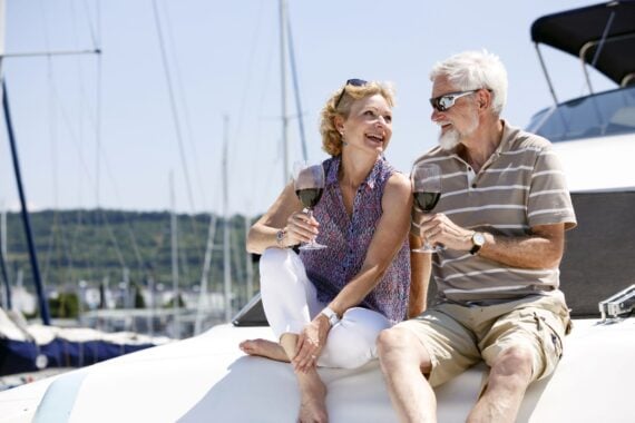 two adults enjoying wine on a boat, smiling
