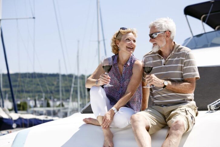 two adults enjoying wine on a boat, smiling