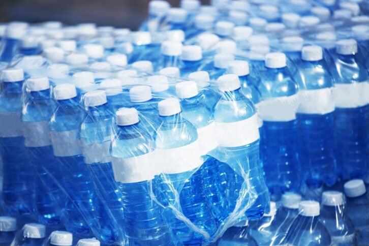 Bulk packs of mineral water in bottles wrapped in plastic ready for distribution