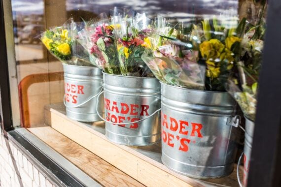 Fairfax: Buckets of flowers with Trader Joe's signs viewed from outside of store