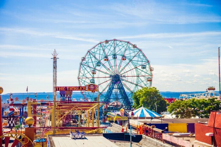 New York, USA -August 29th, 2014: Aerial view of Coney Island amusement park, on the left side is visible a section of the famous Cyclone Rollercoaster, on the right side all the rest of the park during an hot summer day.