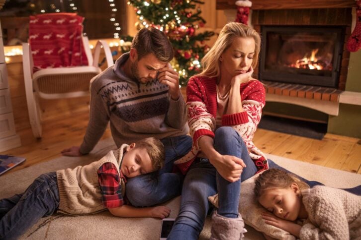 tired parents on christmas, children sleeping in their laps