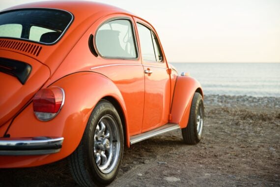 classic orange Volkswagen beetle on sea coast
