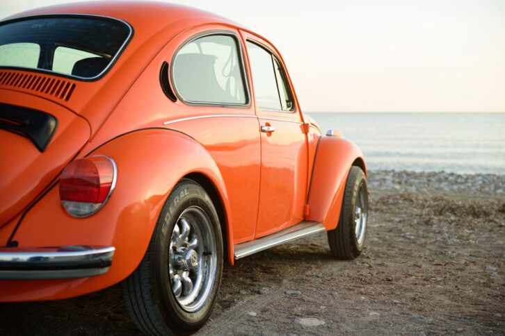 classic orange Volkswagen beetle on sea coast