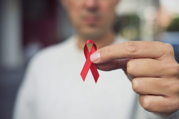 man with red ribbon for the fight against AIDS
