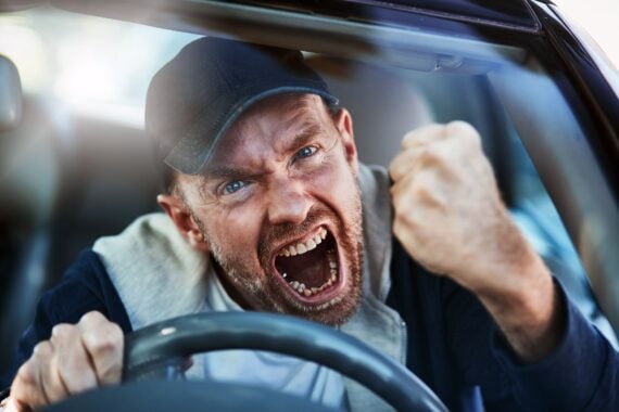 man driving car yelling