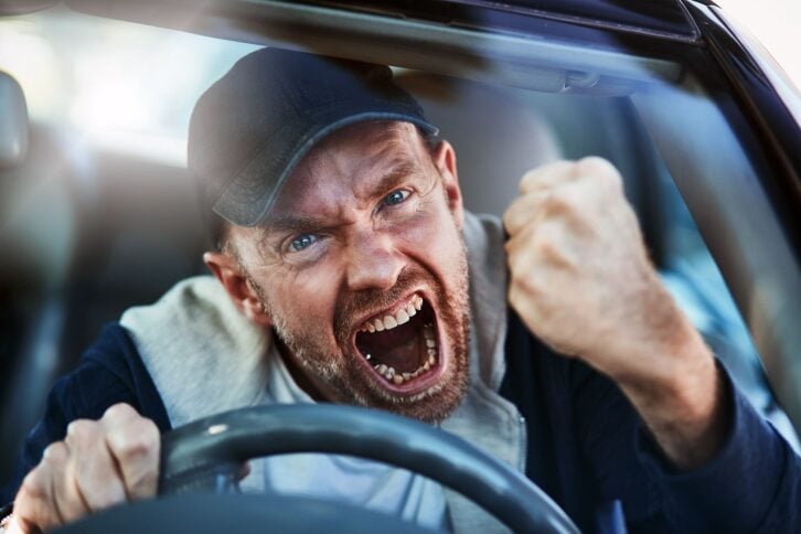 man driving car yelling