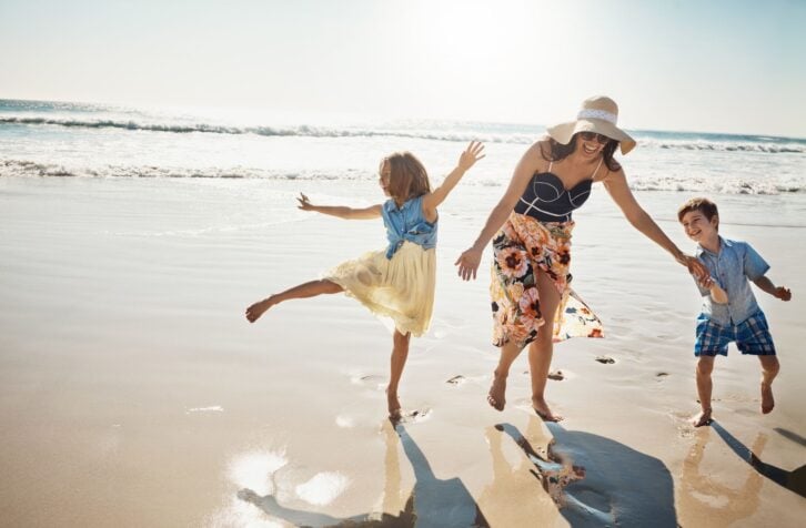 mother bonding with her two little children at the beach
