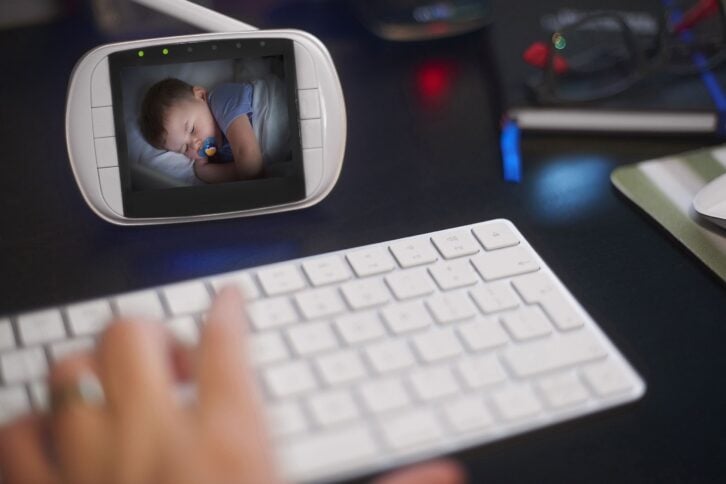 baby monitor on desk while person is typing on keyboard