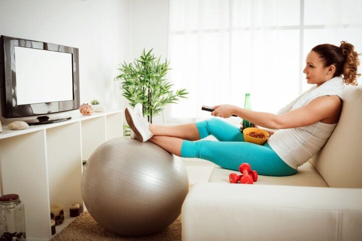woman in sport clothing sitting front of the TV