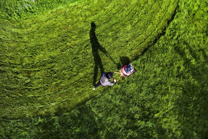 man mowing lawn with lawn mower