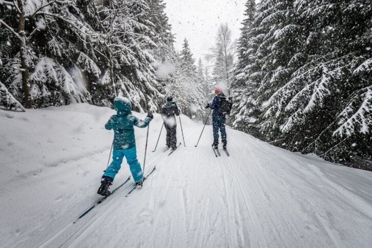 family in snowy winter landscape of giant mountains on cross-country-ski