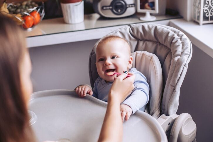 baby being fed in high chair