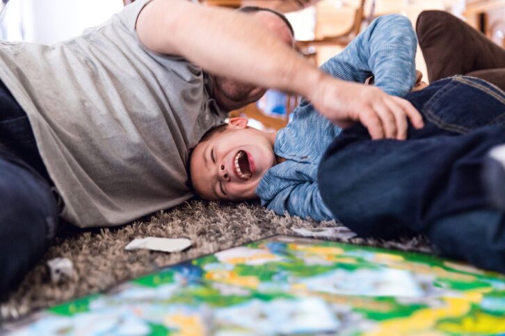 father play at home with son board game