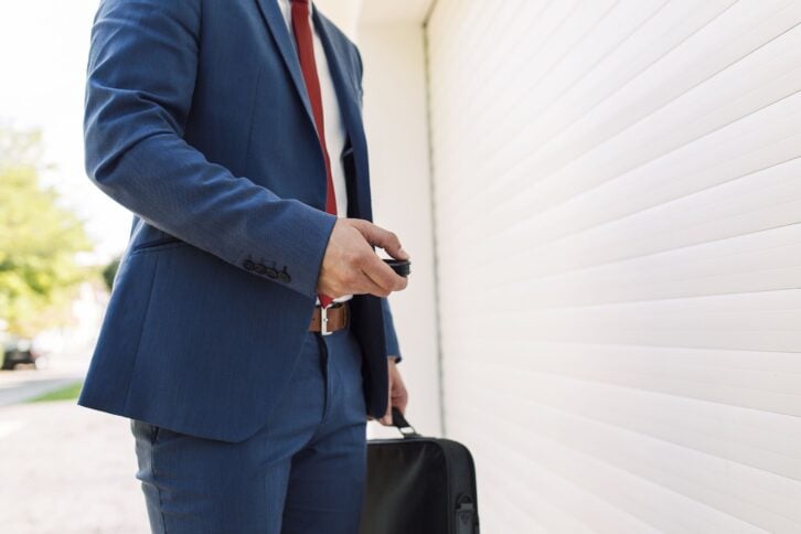 man opening garage door with garage door opener