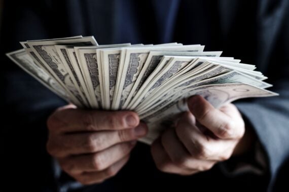 cash spread out in hands