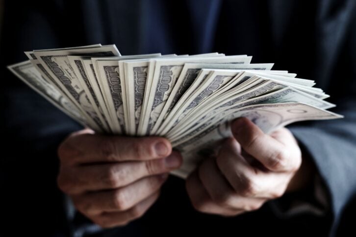 cash spread out in hands
