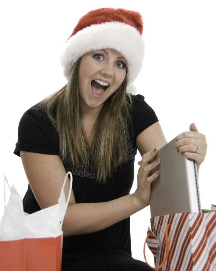 woman getting laptop out of Christmas bag