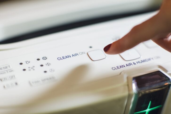 turning on modern air purifier and ionizer