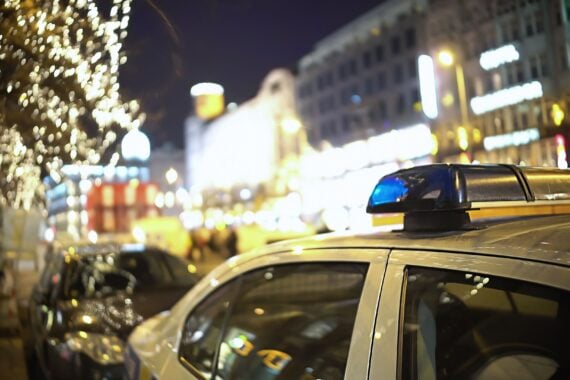 police car off-duty parked on street lined with bars