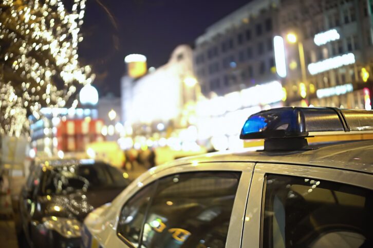 police car off-duty parked on street lined with bars