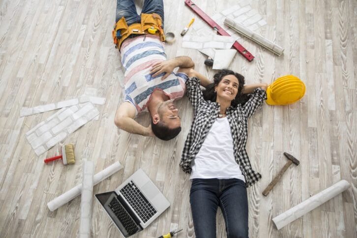 couple renovating and resting on floor