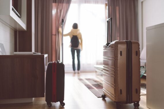 tourist woman opening blinds in hotel room