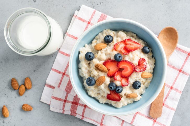 oatmeal porridge with fresh berries and nuts, top view
